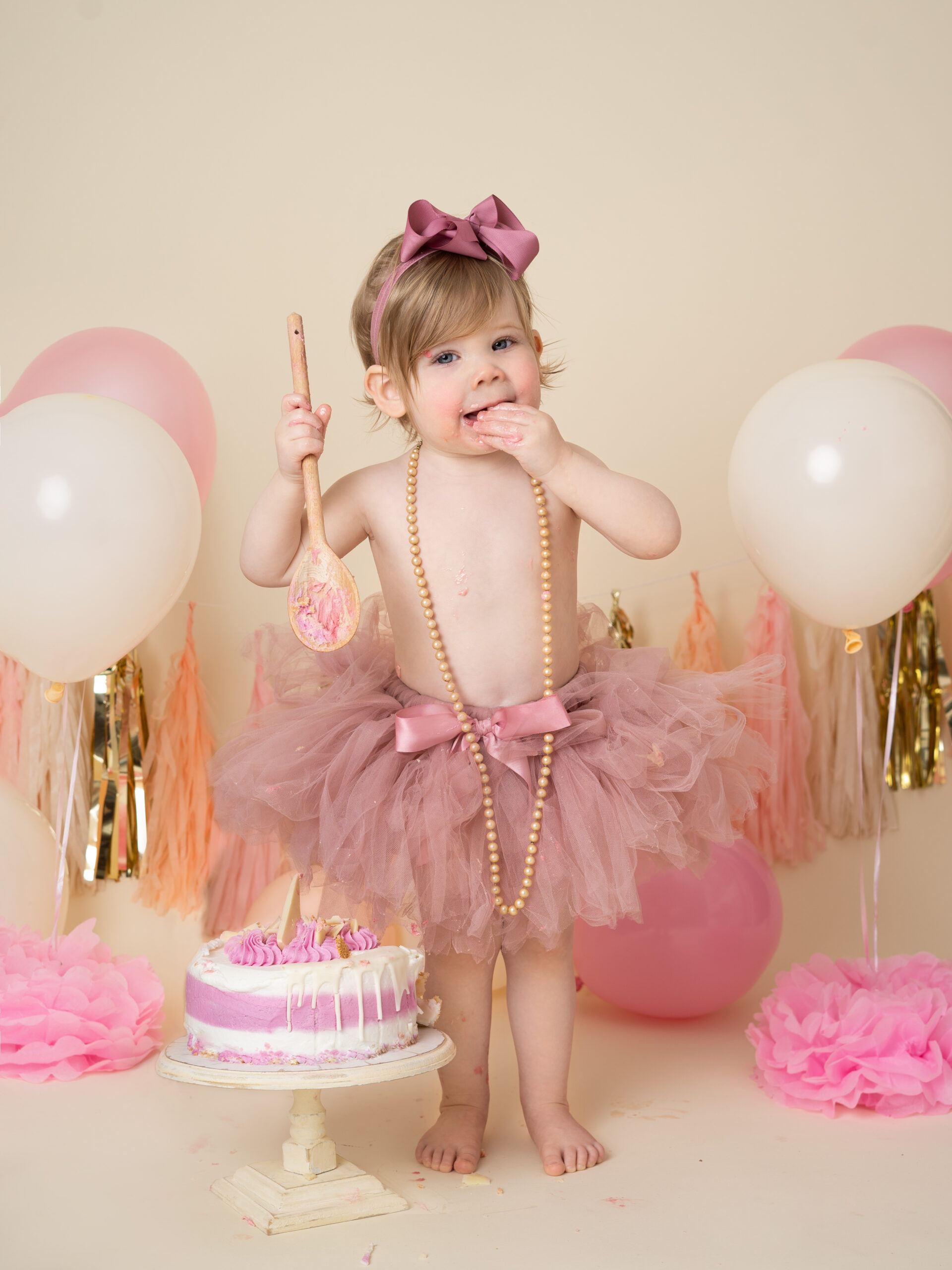 baby girl in a pink tutu and beads by CAKE SMASH PHOTOGRAPHER SURREY