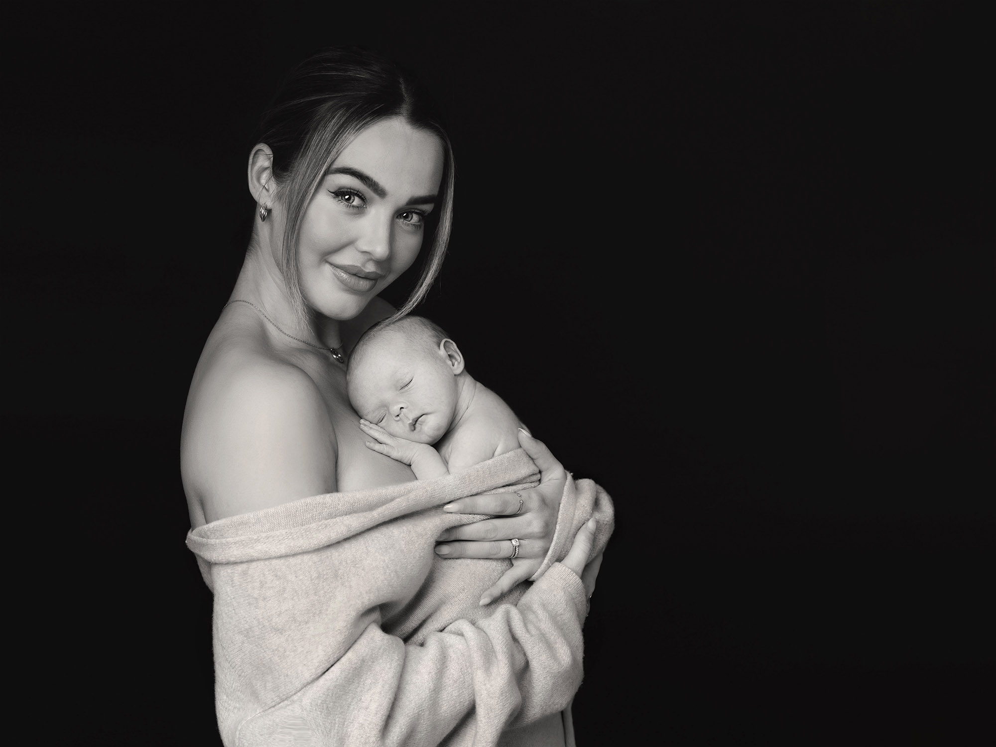 mum holding newborn baby by newborn photographer in Guildford, Surrey