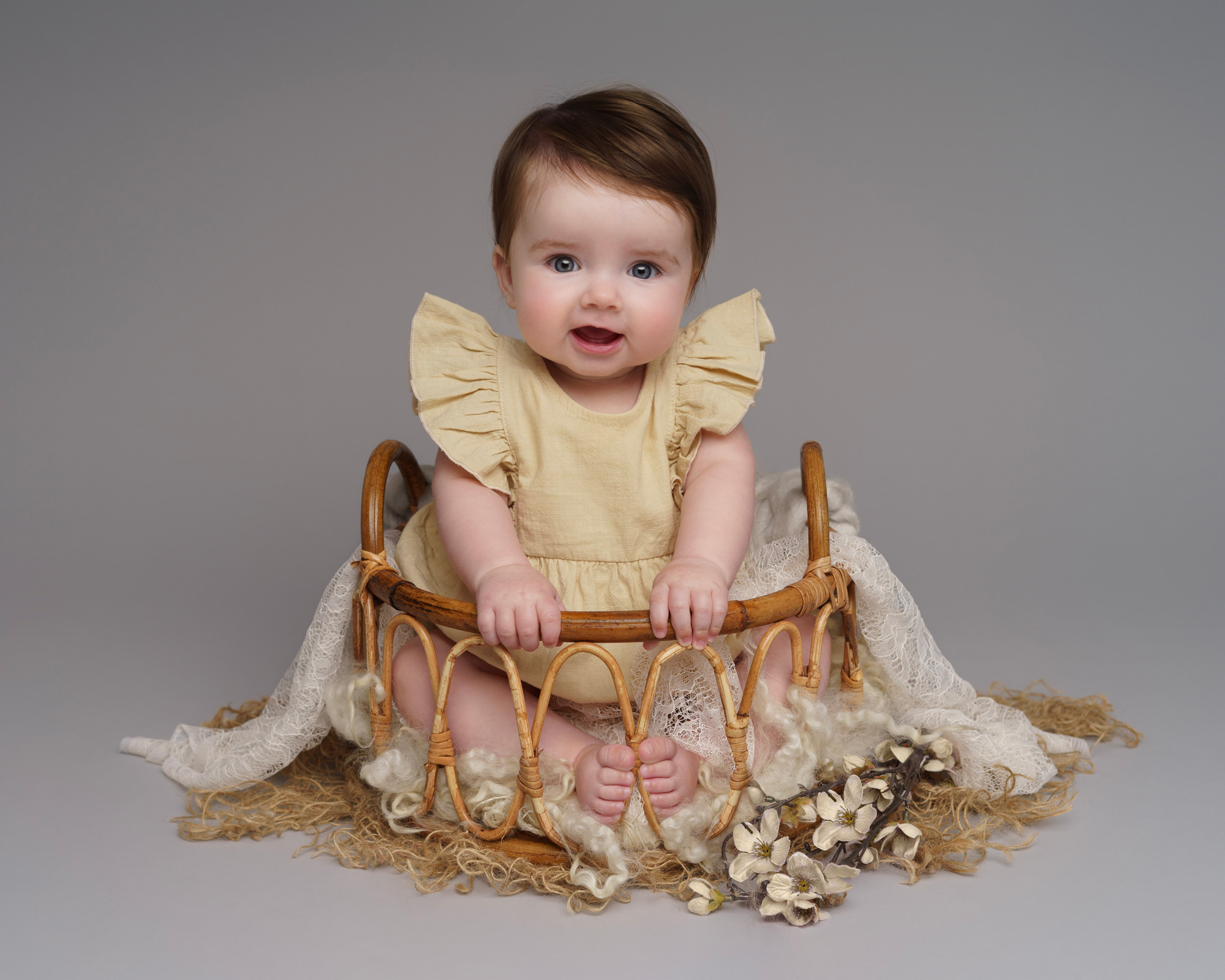 baby sat in basket at 6 months old by BABY & FAMILY PHOTOGRAPHER IN SURREY